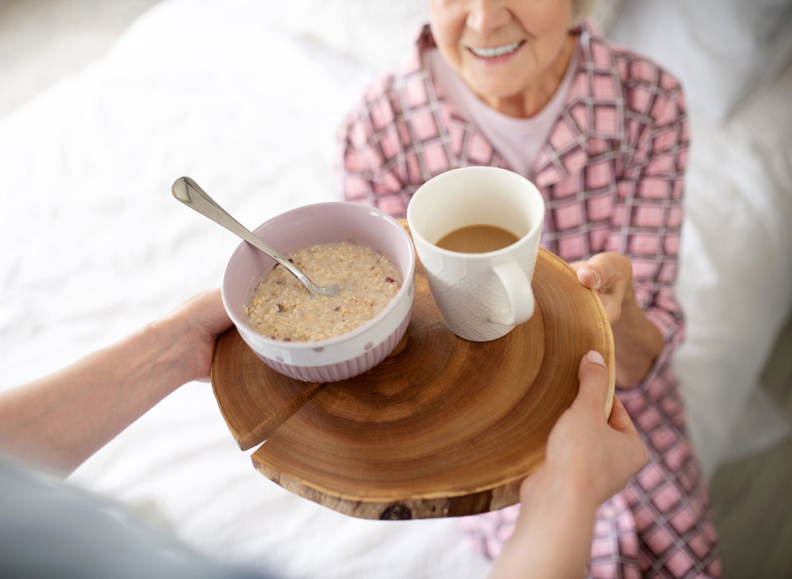 aged-woman-smiling-before-eating-oatmeal-and-drink-2024-10-18-05-22-31-utc